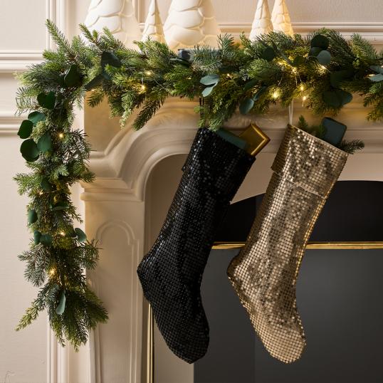 Black and silver metallic stockings hanging on fireplace mantle