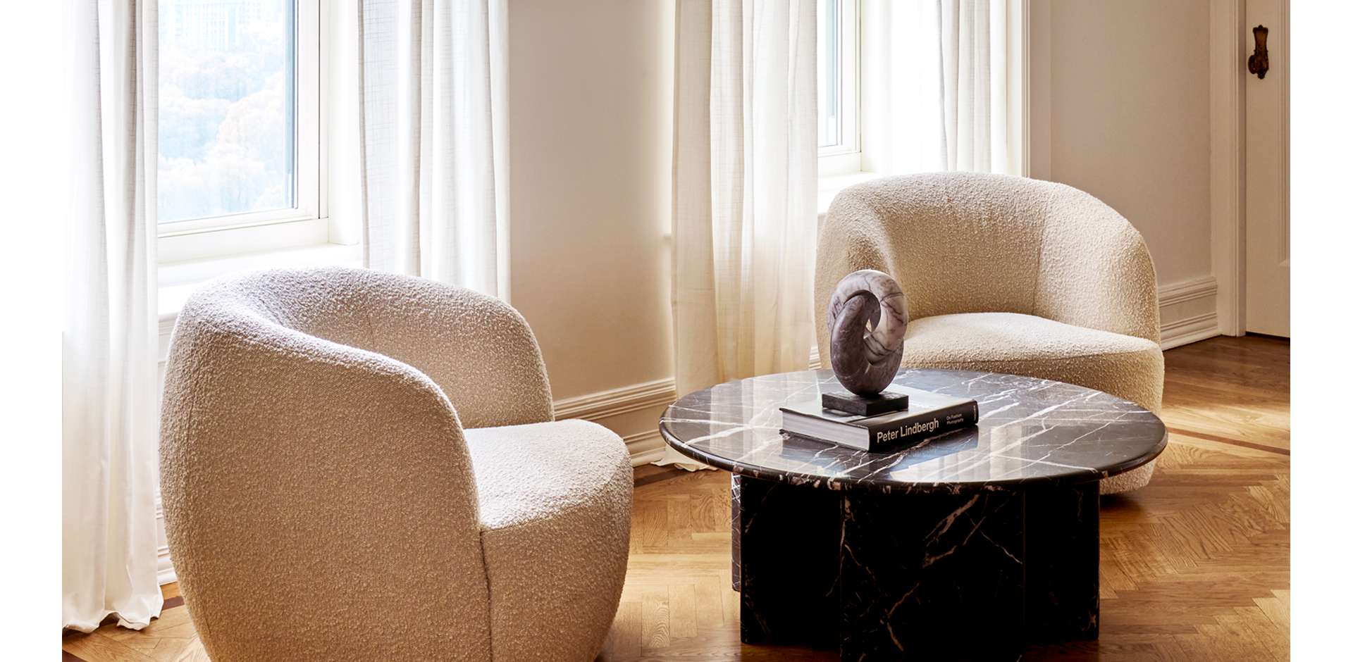 Large and spacious room with brown couch and white accent chair with a rug between them