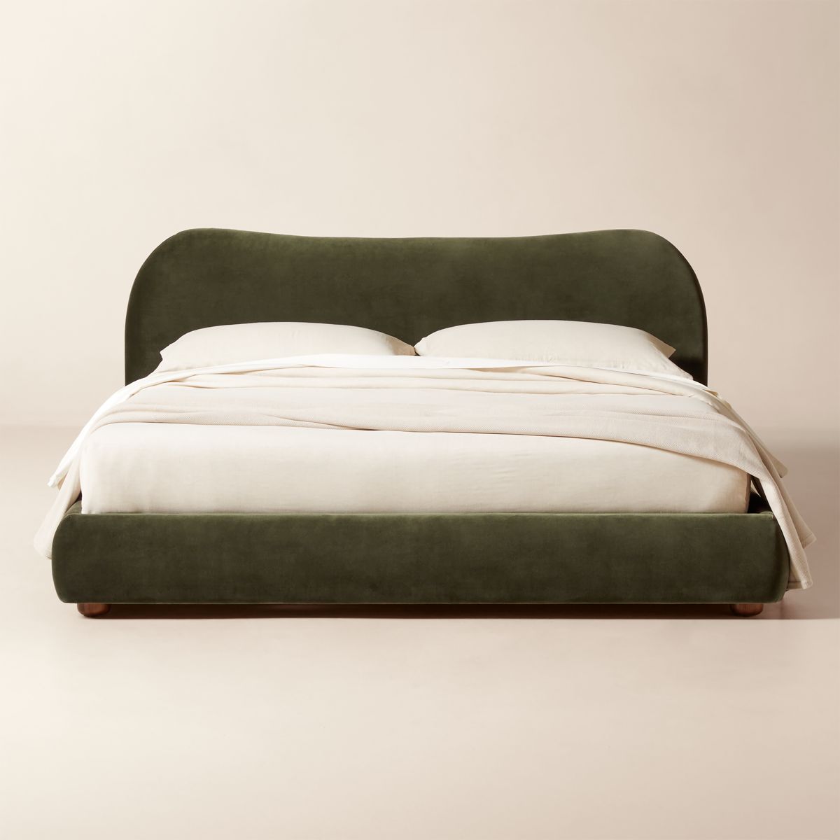 Olive green velvet upholstered bed with curved silhouette